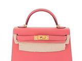 a small pink and beige leather handbag with gold hardware