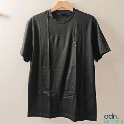 a black t - shirt hanging on a wall next to a hanger