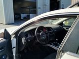 a white car with its door open in front of a building