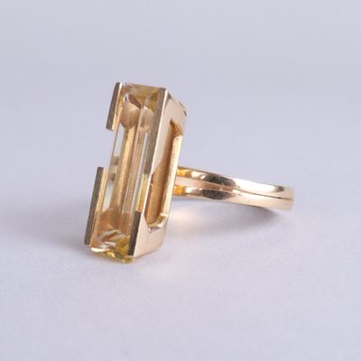 un gros plan d'une bague en or sertie d'une grosse citrine