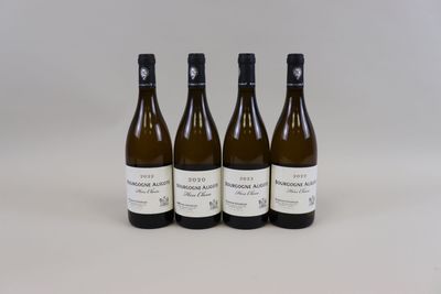 trois bouteilles de vin posées sur une table blanche