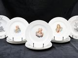 six assiettes blanches sur lesquelles figurent des portraits de personnes sur fond noir