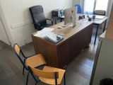 a desk with two chairs and a computer on it