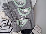 a lot of baby clothes that are on a bed