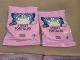 deux sachets de tortillas vendues dans la rue posés sur une boîte en carton