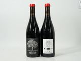 two bottles of wine sitting next to each other on a white surface