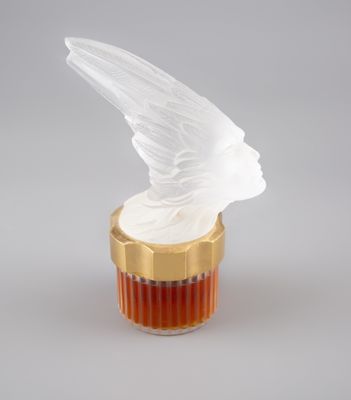 une bouteille en verre surmontée d'un oiseau blanc