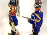 two figurines of a soldier and a soldier with a sword