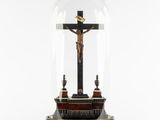 a statue of jesus on the cross under a glass dome