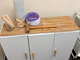 a white cabinet with wooden handles in a bathroom
