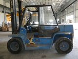 un chariot élévateur bleu garé dans un entrepôt