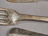 three forks and two spoons sitting on a table