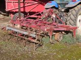 a tractor that is parked next to a red trailer