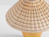 a yellow vase with a straw hat on top of it