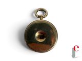 a close up of a pocket watch on a white surface