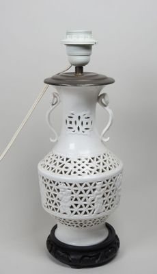 une image représentant un vase blanc surmonté d'un couvercle en bois