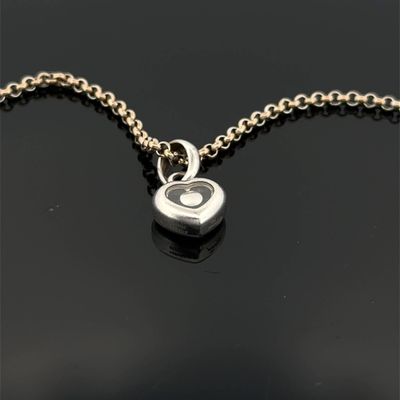un gros plan d'un pendentif en forme de cœur en argent monté sur une chaîne