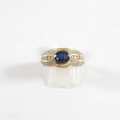 gros plan d'une bague avec une pierre bleue et des diamants