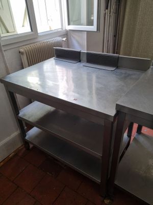 une table sur laquelle est posé un ordinateur portable, dans une pièce