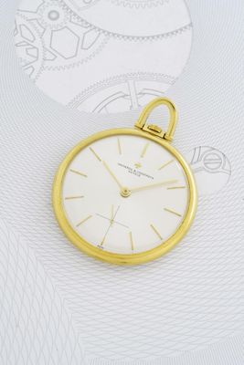gros plan d'une montre de poche en or sur fond blanc