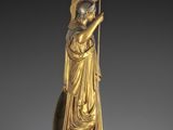 a gold statue of a woman holding a spear and shield