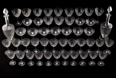 a lot of wine glasses and a bottle on a table