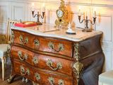 un tableau accroché au mur au-dessus d'une commode dans une pièce