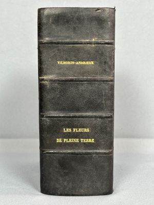 un livre noir avec des inscriptions jaunes, posé sur une table