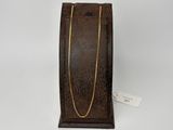 une boîte à bijoux en cuir marron ornée d'une chaîne dorée