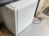un réfrigérateur blanc posé devant la porte d'un garage