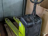 un chariot élévateur jaune posé sur une palette dans un entrepôt