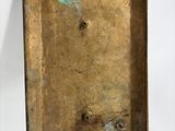 an old brass plate with a small hole in the middle