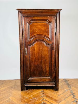 une vieille armoire en bois posée sur un sol en bois dur