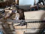 de nombreuses boîtes, les unes sur les autres, dans un panier en fil de fer posé par terre