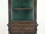 an old wooden cabinet with a green glass door and shelves