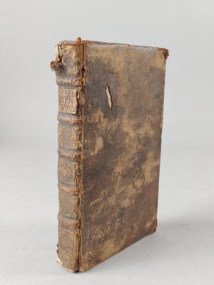 an old book sitting on top of a table next to a white wall