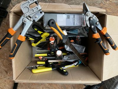 une boîte remplie d'outils posés sur le sol