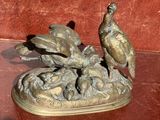 une statue en bronze représentant un faisan posée sur une table