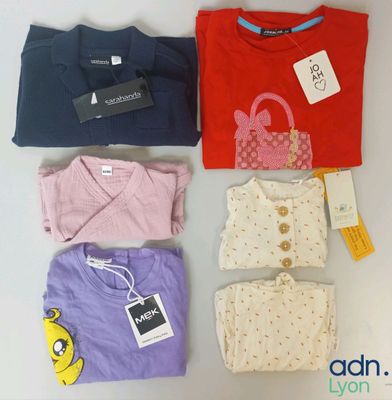 a group of t - shirts and a purse are sitting on a table