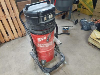 a red and black vacuum on a cart in a garage