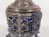 an antique silver and blue glass covered box with a bird on top
