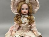 un gros plan d'une poupée portant une robe rose et un chapeau