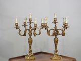 paire de chandeliers anciens en laiton posés sur un socle en bois