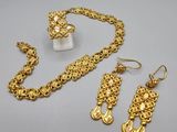 a close up of a necklace, earrings and ring on a table