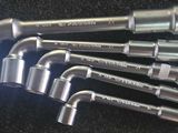 six wrenches that are sitting on a black surface
