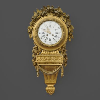 une horloge dorée accrochée au mur sur un fond noir