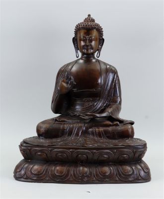 bronze statue of a seated buddha on a pedestal with a white background
