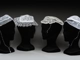 trois têtes de mannequin ornées de voiles et de dentelle