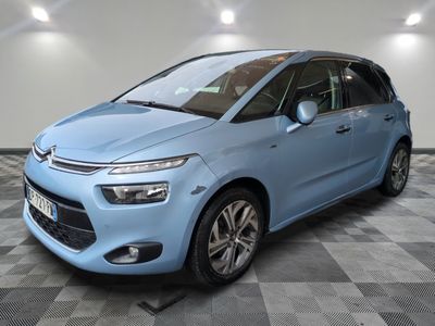 une Citroën bleue garée dans un garage au sol carrelé