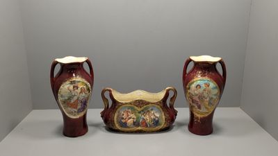 deux vases décorés de peintures, posés sur une surface blanche